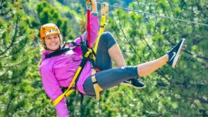 Claire wearing a pink jacket and zip lining